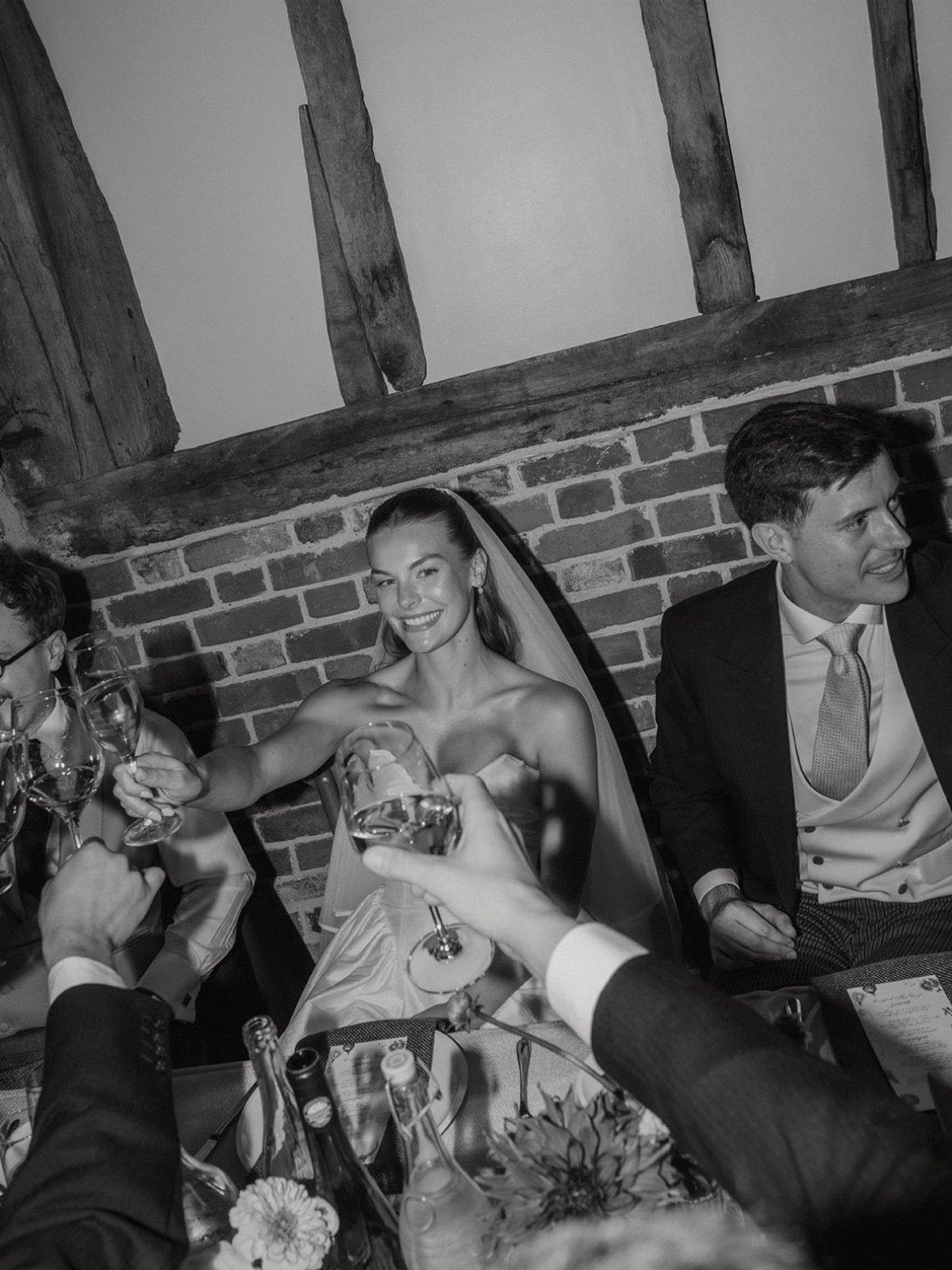 17 Wedding Ideas Pictures to Show Your Photographer 10 Bride and groom smiling and raising wine glasses during a wedding reception toast.
