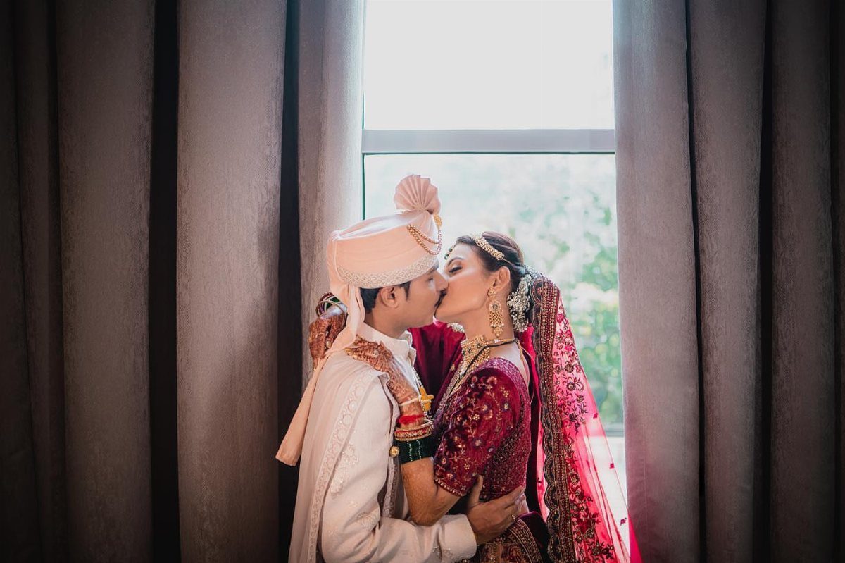 17 Wedding Ideas Pictures to Show Your Photographer 1 Indian bride and groom in traditional wedding attire kissing by a bright window