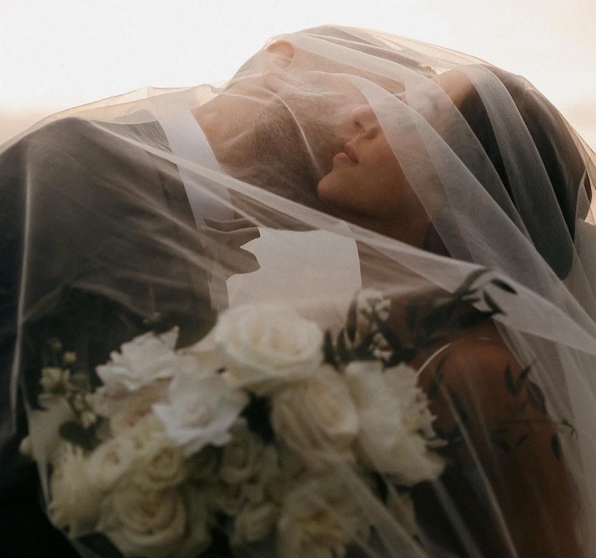 17 Wedding Ideas Pictures to Show Your Photographer 13 Bride and groom embracing under a sheer white wedding veil with white roses.