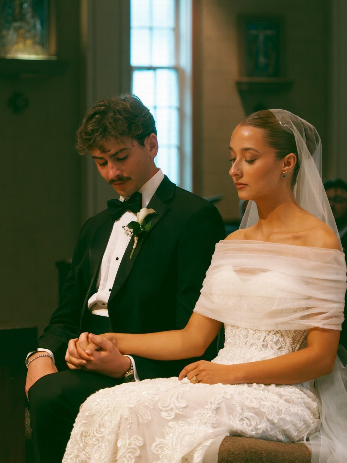 17 Wedding Ideas Pictures to Show Your Photographer 9 Bride and groom holding hands while sitting during a wedding ceremony in a church.