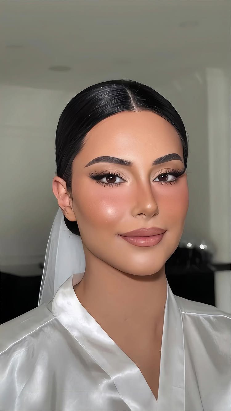 Woman in bridal attire with radiant highlighter on her cheeks and nose.