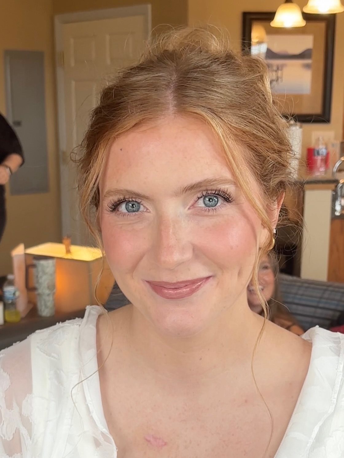 Woman with blue eyes wearing subtle, natural wedding makeup and a white dress.