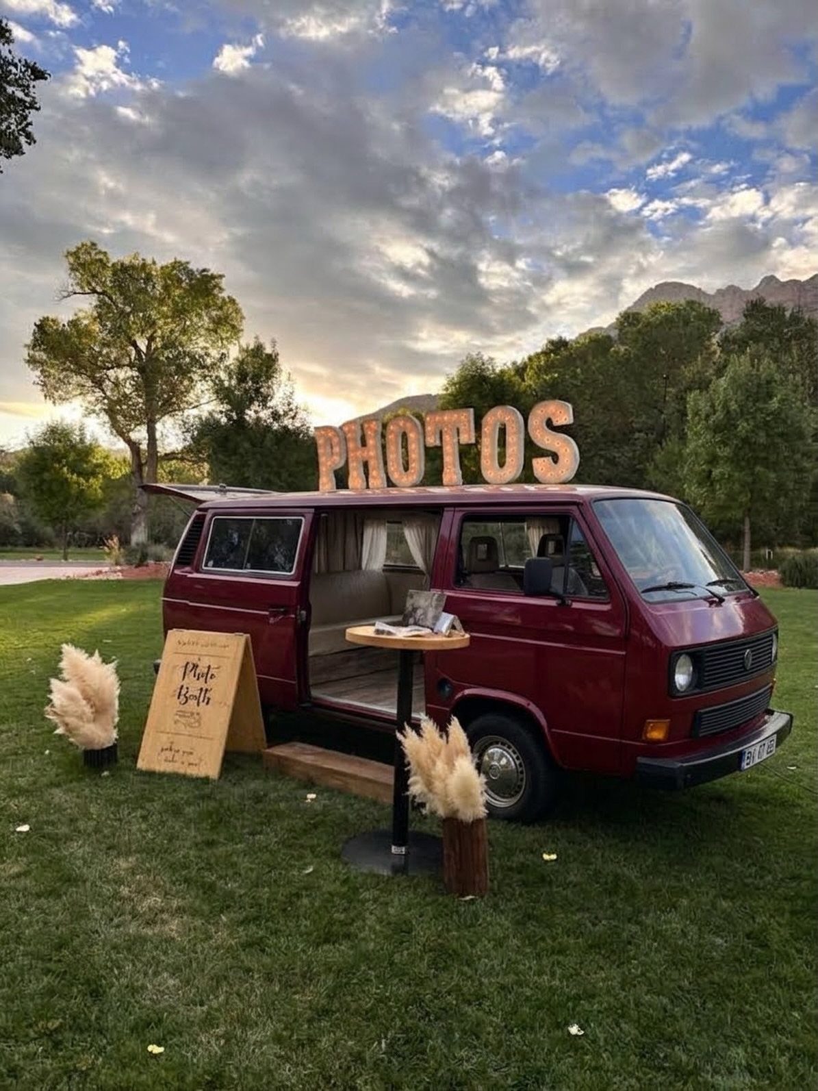 Best Wedding Photo Station Ideas: 8 Booths and Backdrops 5 Maroon vintage VW bus photo booth with a large PHOTOS sign on top.