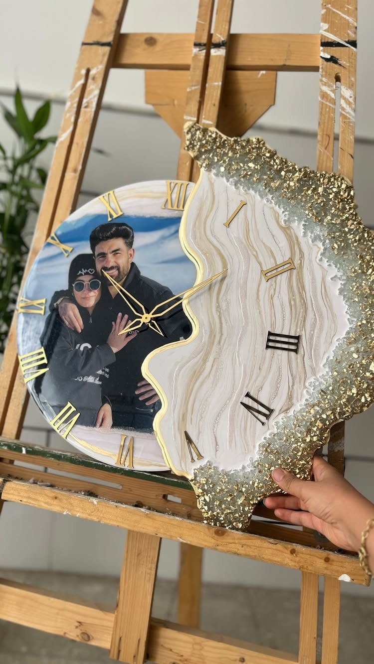 22 Wedding Present Ideas for Couples to Treasure 17 Custom resin wall clock with a couple's photo and gold glitter accents on easel