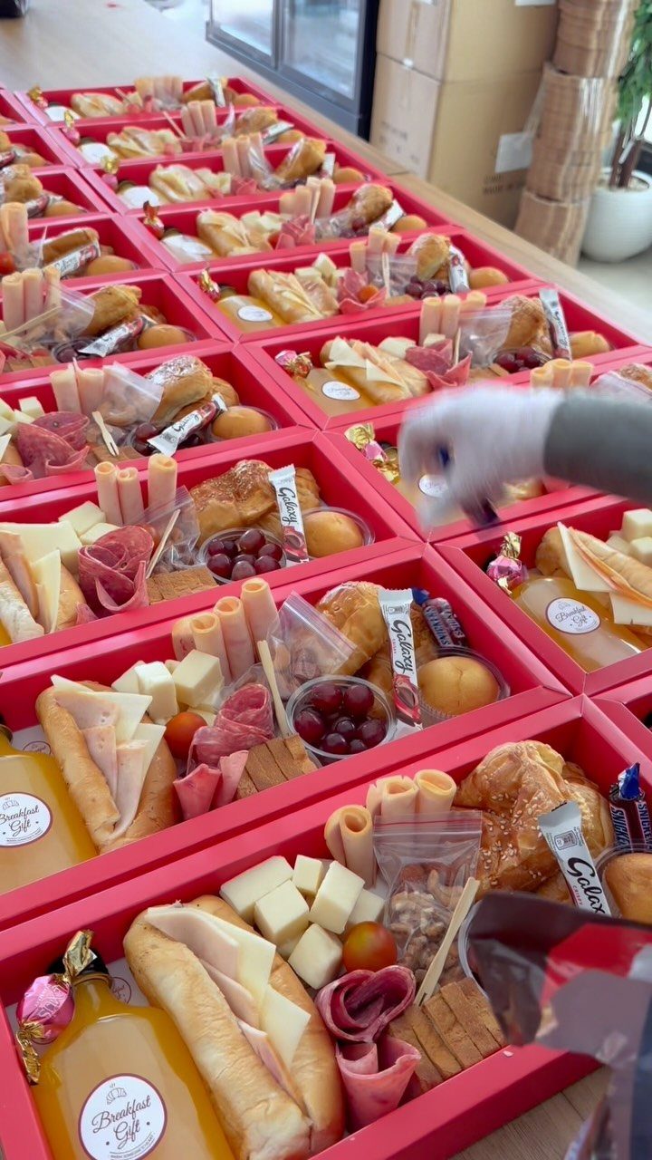 22 Wedding Present Ideas for Couples to Treasure 19 Gourmet food gift boxes with baguettes, cheese, and juice arranged in red containers.