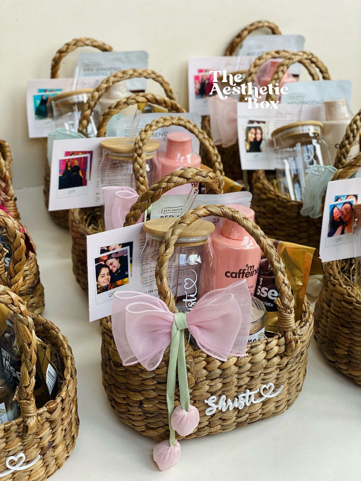 22 Wedding Present Ideas for Couples to Treasure 13 Woven gift baskets containing pink toiletries, jars, and photos with a pink bow.