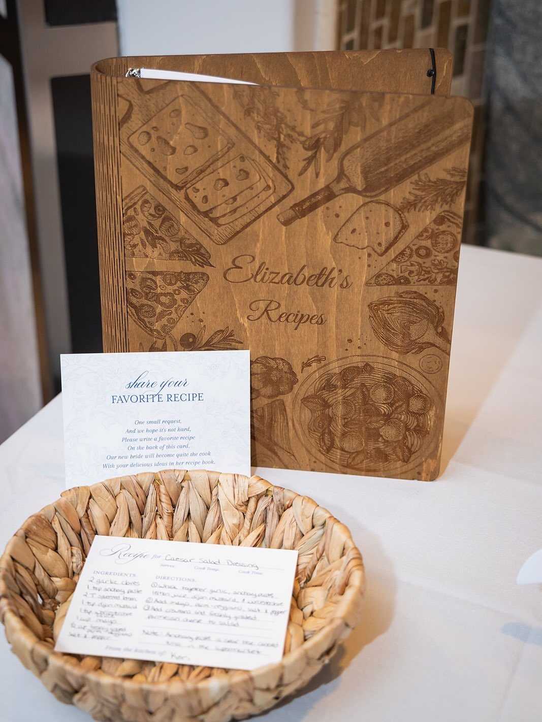 22 Wedding Present Ideas for Couples to Treasure 4 Wooden recipe book engraved with Elizabeth's Recipes next to a basket of recipe cards.