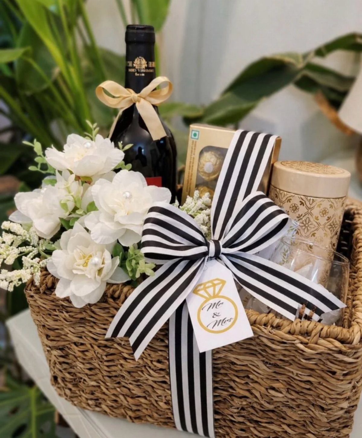 22 Wedding Present Ideas for Couples to Treasure 15 Wicker gift basket with wine, white flowers, and a Mr and Mrs tag.
