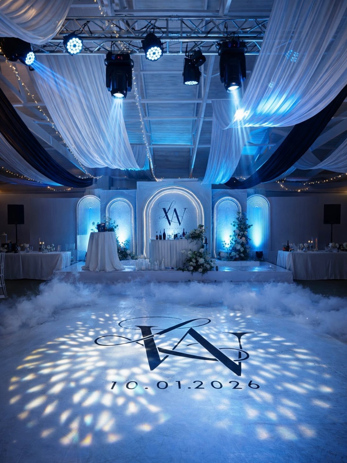 Wedding reception dance floor with blue lighting, fog, and a projected monogram date.