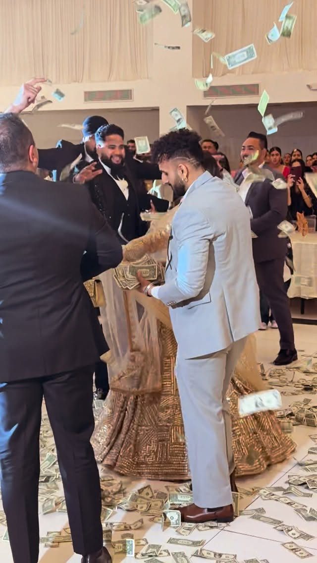 13 Wedding Reception Ideas for Guests Who Love Fun 6 Men in suits and a person in gold dress with money falling around them