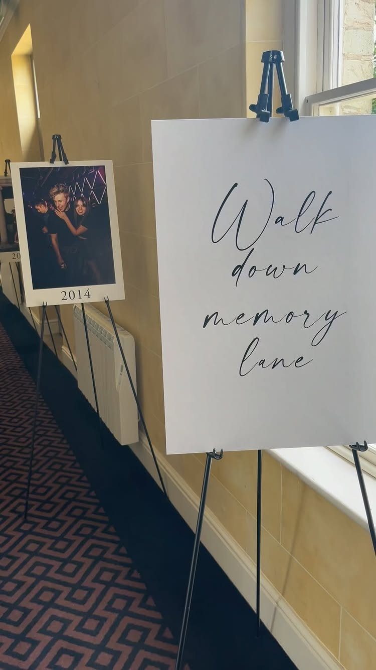13 Wedding Reception Ideas for Guests Who Love Fun 5 Memory lane display with a scripted sign and framed photo on black easels.