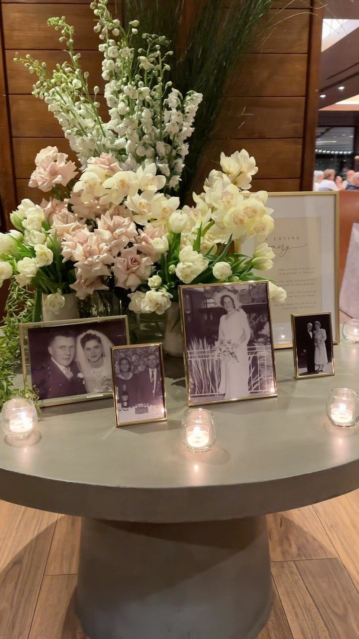 13 Wedding Reception Ideas for Guests Who Love Fun 10 Remembrance table with framed black and white photos, white flowers, and tea light candles.