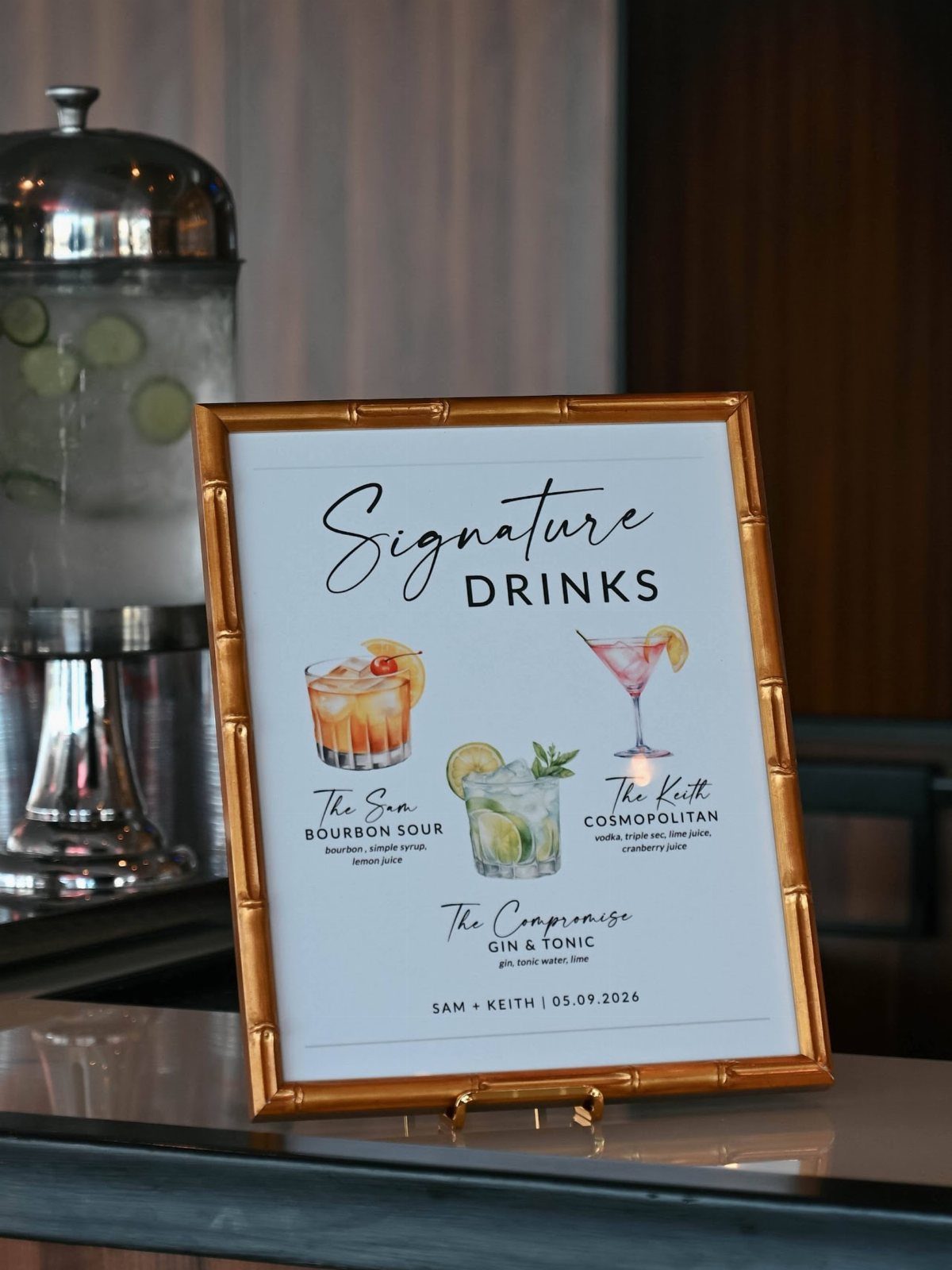 13 Wedding Reception Ideas for Guests Who Love Fun 1 Gold framed signature drinks menu with cocktail illustrations on a bar counter
