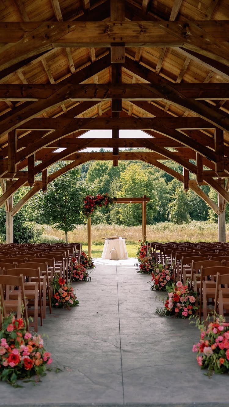 17 Wedding Reception Venues for Every Style and Budget 2 Wooden pavilion wedding ceremony setup with floral arrangements and forest background