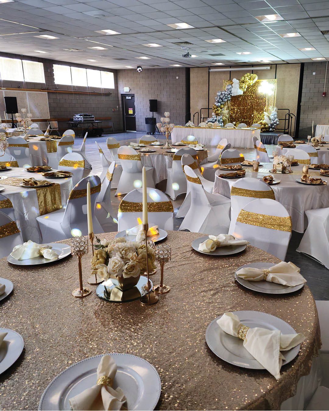17 Wedding Reception Venues for Every Style and Budget 8 Wedding reception setup in a community center with gold sequin tablecloths and white chairs.
