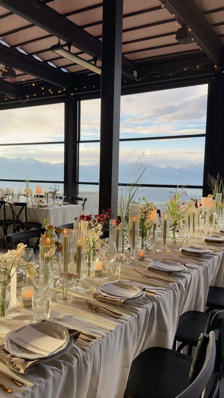 17 Wedding Reception Venues for Every Style and Budget 16 Long wedding reception table with floral centerpieces and candles overlooking distant mountains