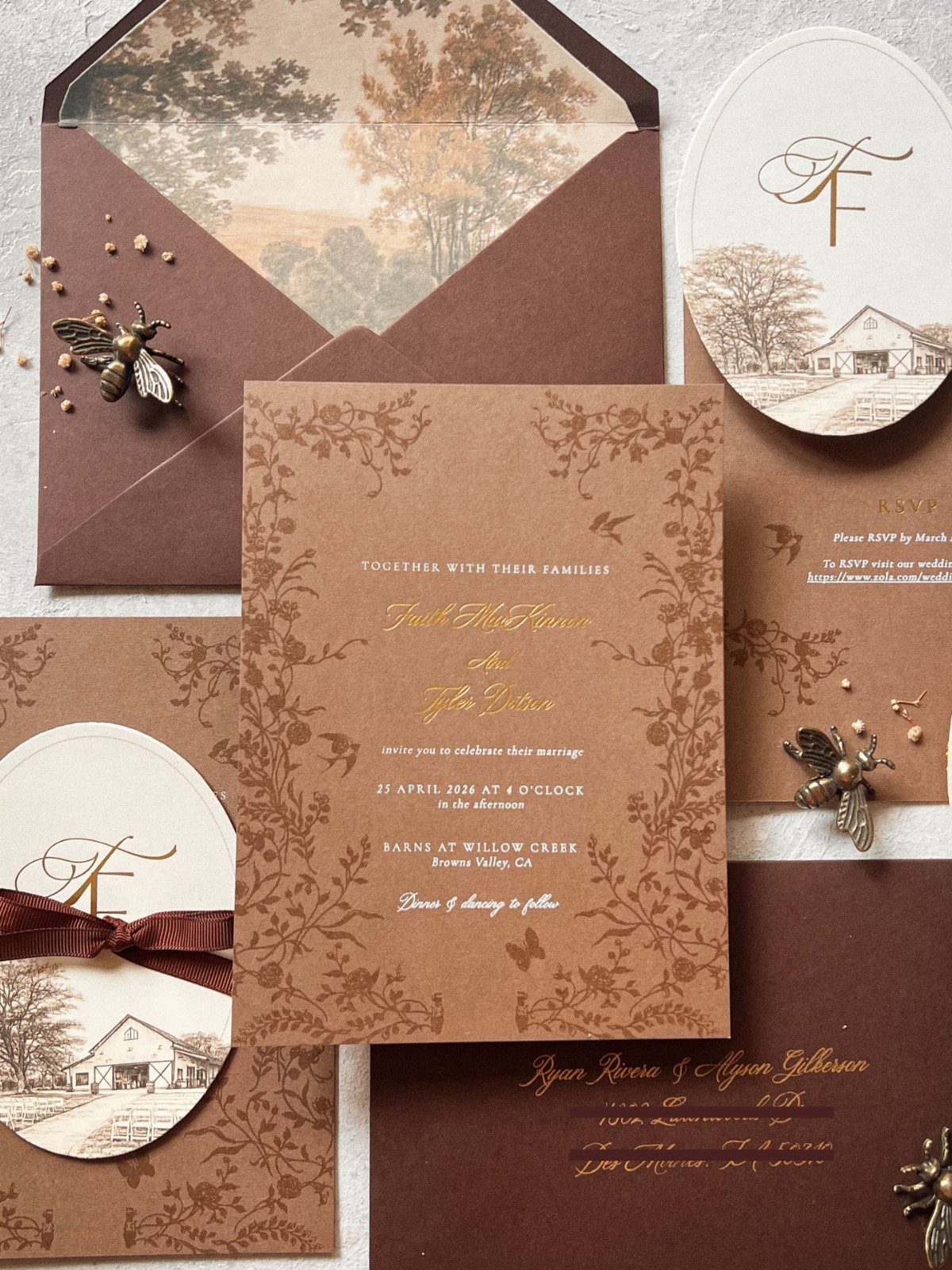 Brown kraft paper wedding invitations with gold calligraphy and barn illustrations.