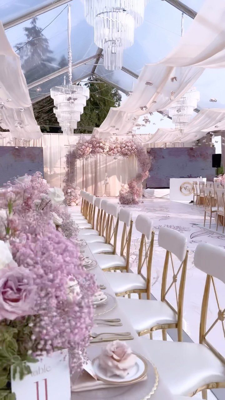 10 Wedding Venue Decorations for a Standout Celebration 4 Pink floral arch at the end of a white wedding aisle in a tent