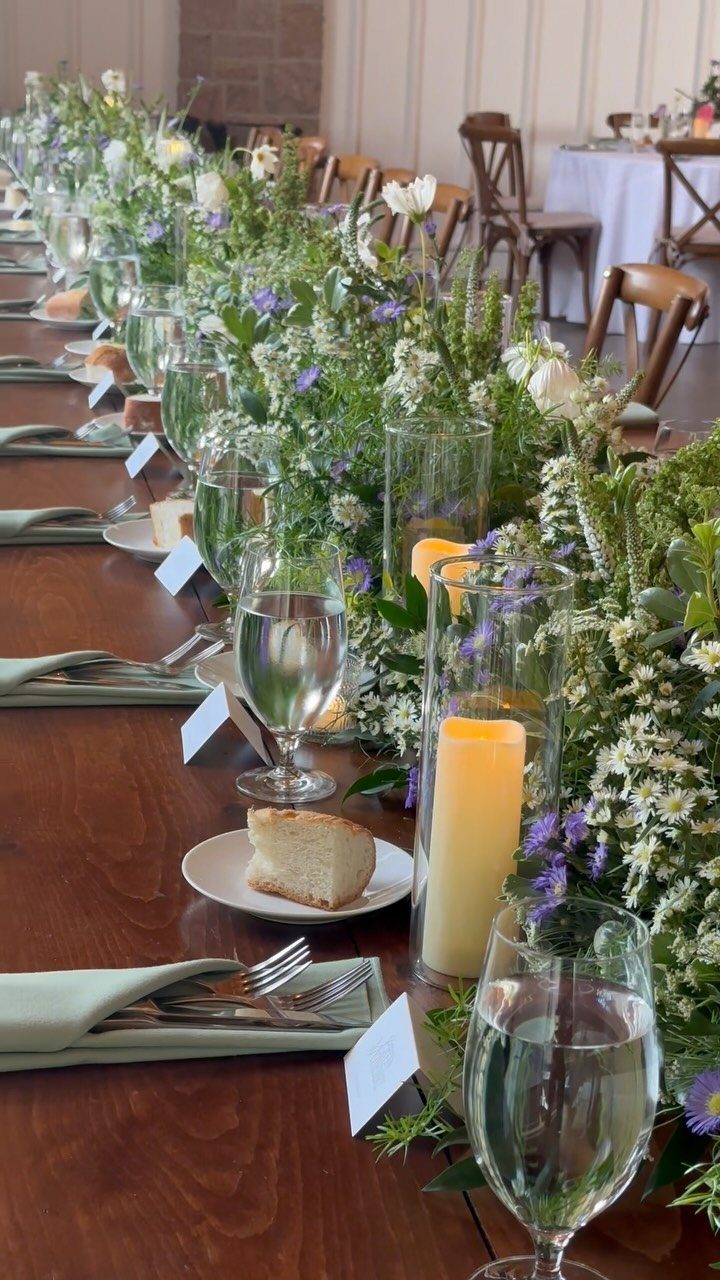 10 Wedding Venue Decorations for a Standout Celebration 3 Wooden wedding table with a greenery and wildflower runner, candles, and elegant place settings.