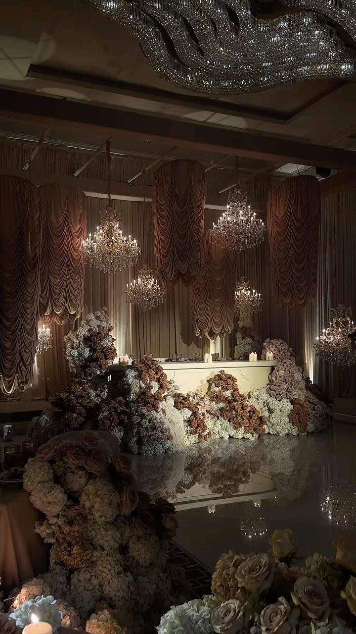 10 Wedding Venue Decorations for a Standout Celebration 1 Crystal chandeliers and floral arrangements decorating a luxurious indoor wedding venue.
