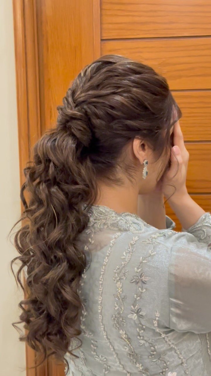 Woman with curly brown hair in a low ponytail and twisted updo.